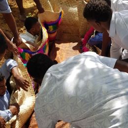 Placing the Fijian mats in the grave to cover the coffin